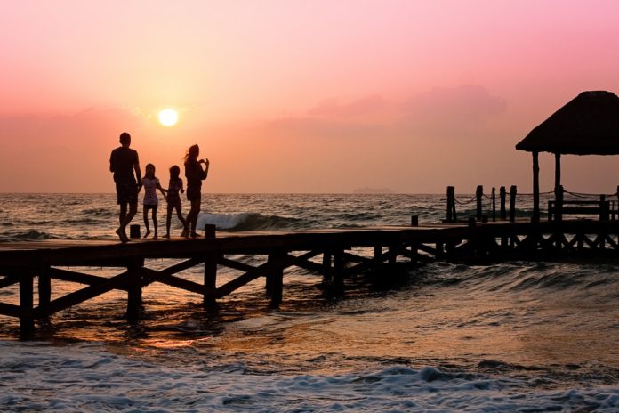 Family Standing on Dock at Sunset
